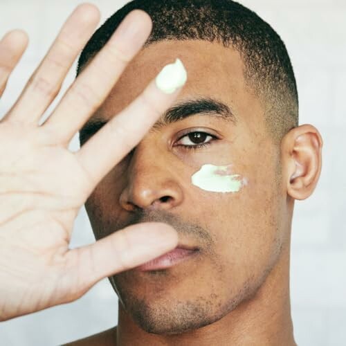 Man applying skincare cream to face