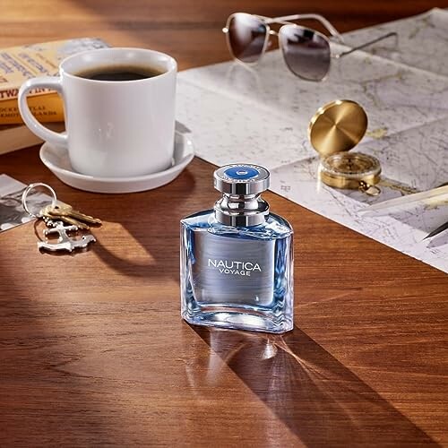 Nautica Voyage perfume with coffee, map, and sunglasses.